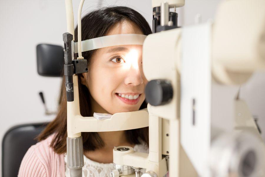 Profesionales ópticos realizan un examen de salud visual a una mujer para ver cómo está su vista