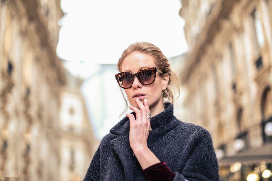 mujer fotografiada con gafas de sol en una ciudad
